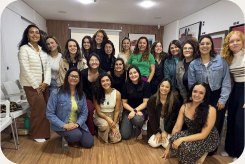Grupo de mulheres em pé e agachadas durante o encontro presencial Ritmo da Carreira